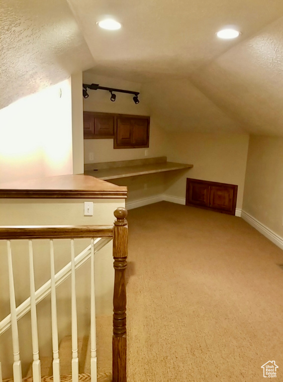 Additional living space with light carpet and lofted ceiling