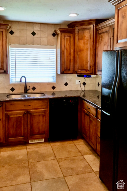 Kitchen with black appliances, sink, tasteful backsplash, and light tile floors