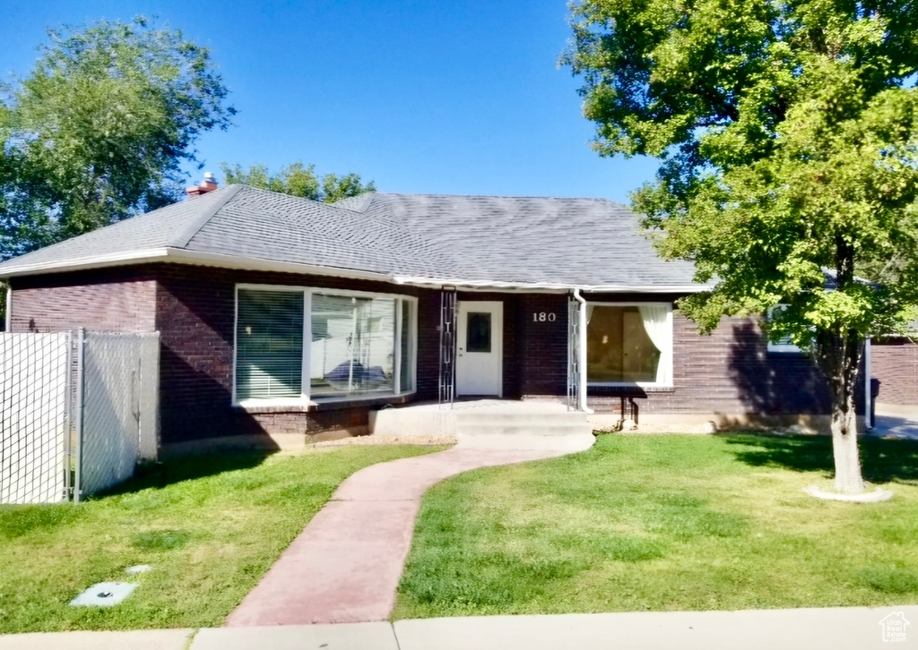 Single story home featuring a front lawn