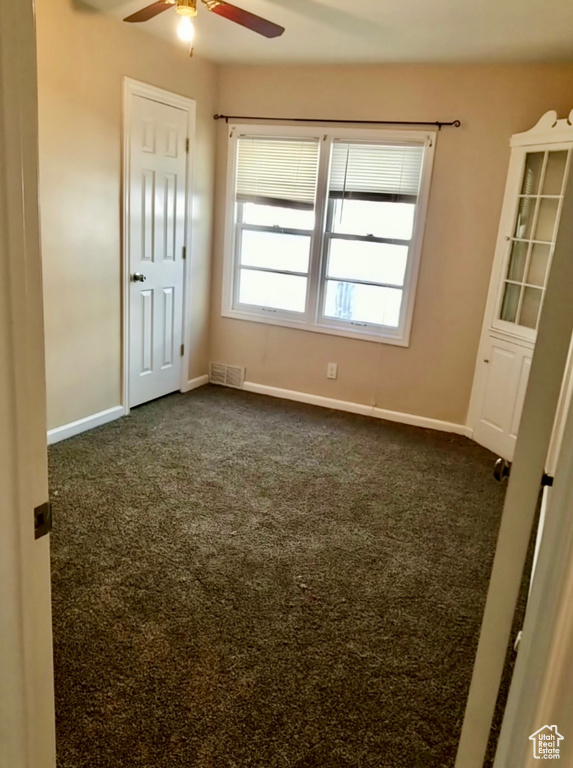 Carpeted empty room featuring ceiling fan