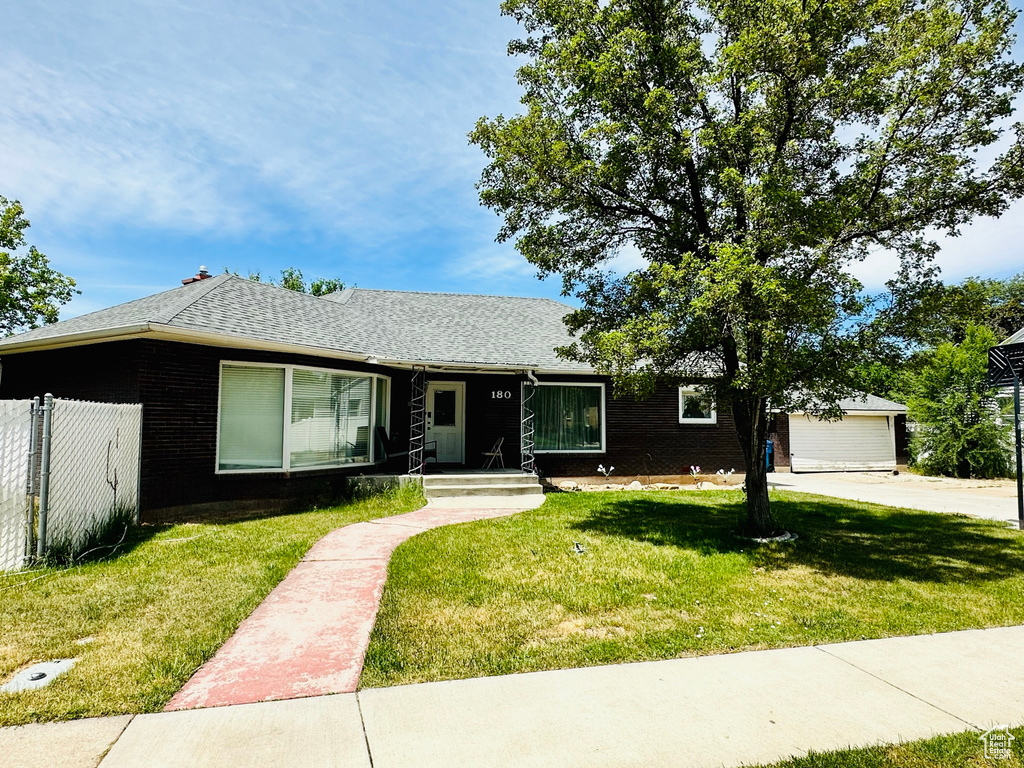 Ranch-style home with a garage and a front lawn