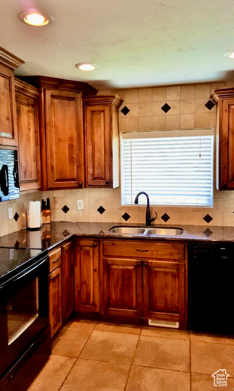 Kitchen with black appliances, backsplash, sink, plenty of natural light, and light tile floors