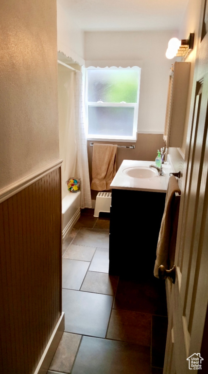 Bathroom featuring tile flooring, large vanity, and shower / bath combo