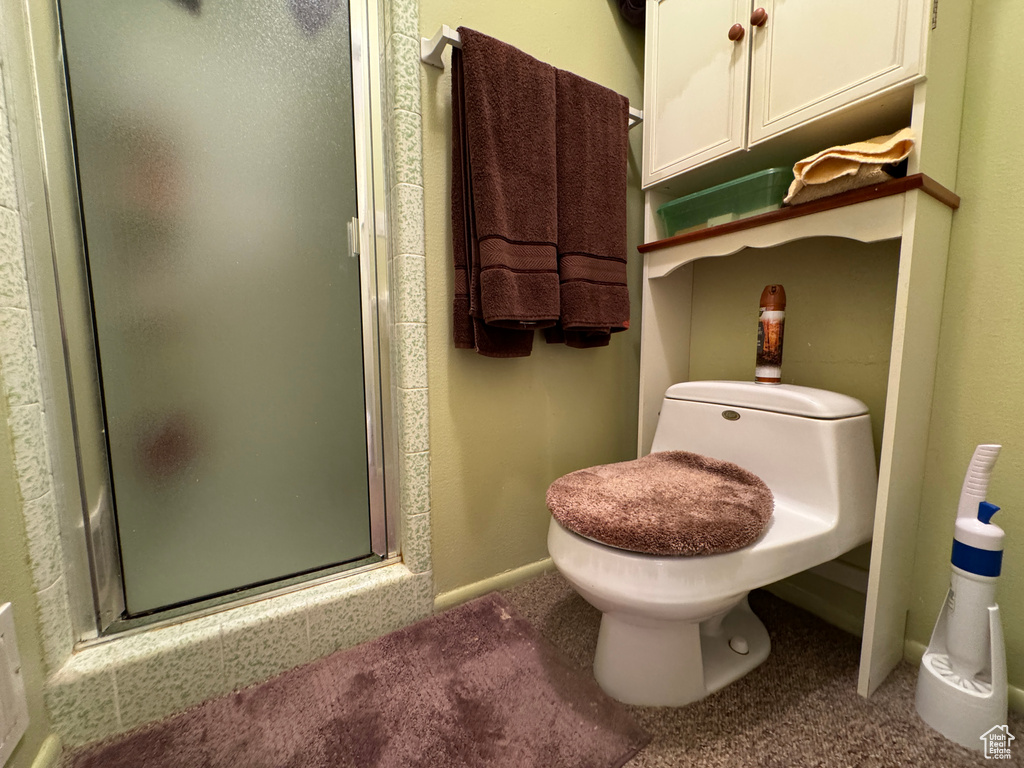 Bathroom with a shower with shower door and toilet