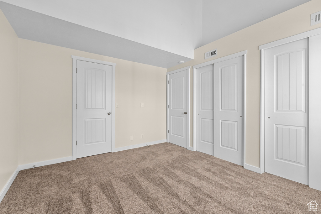 Unfurnished bedroom with two closets and carpet flooring