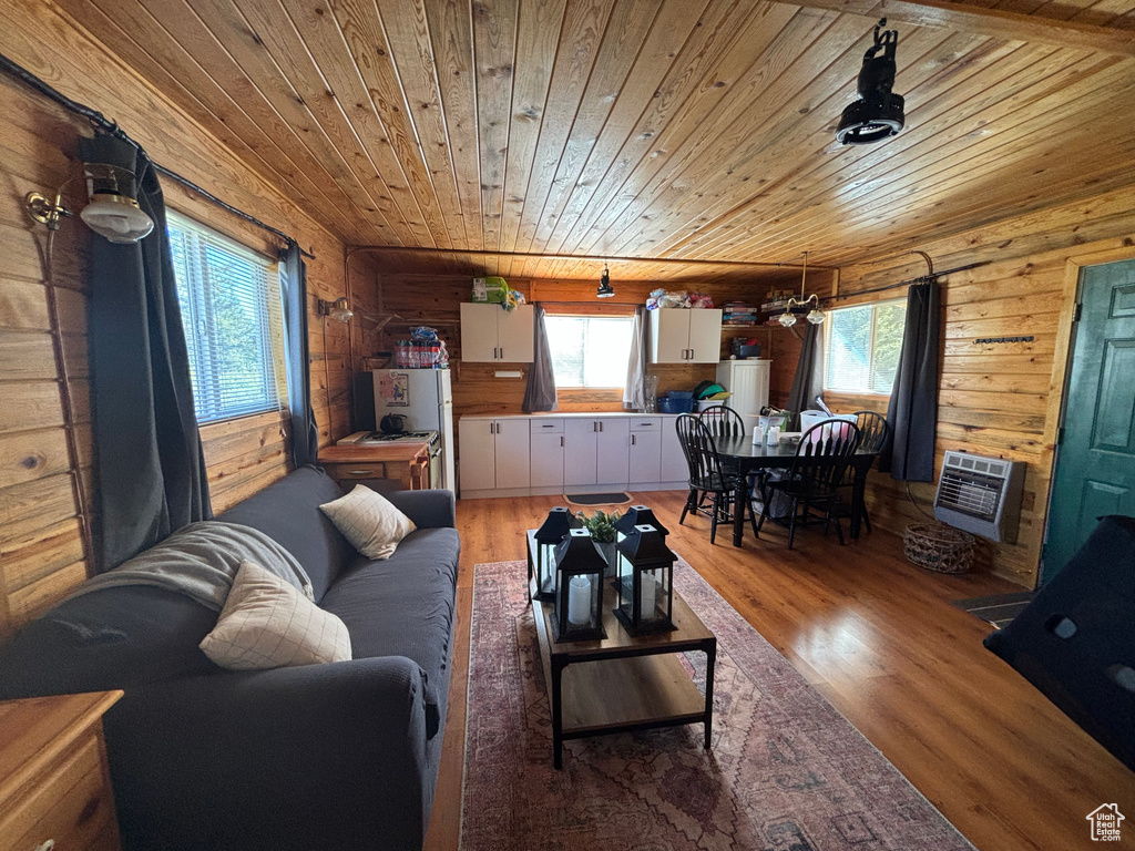 Living room featuring wooden walls, hardwood / wood-style floors, and wood ceiling