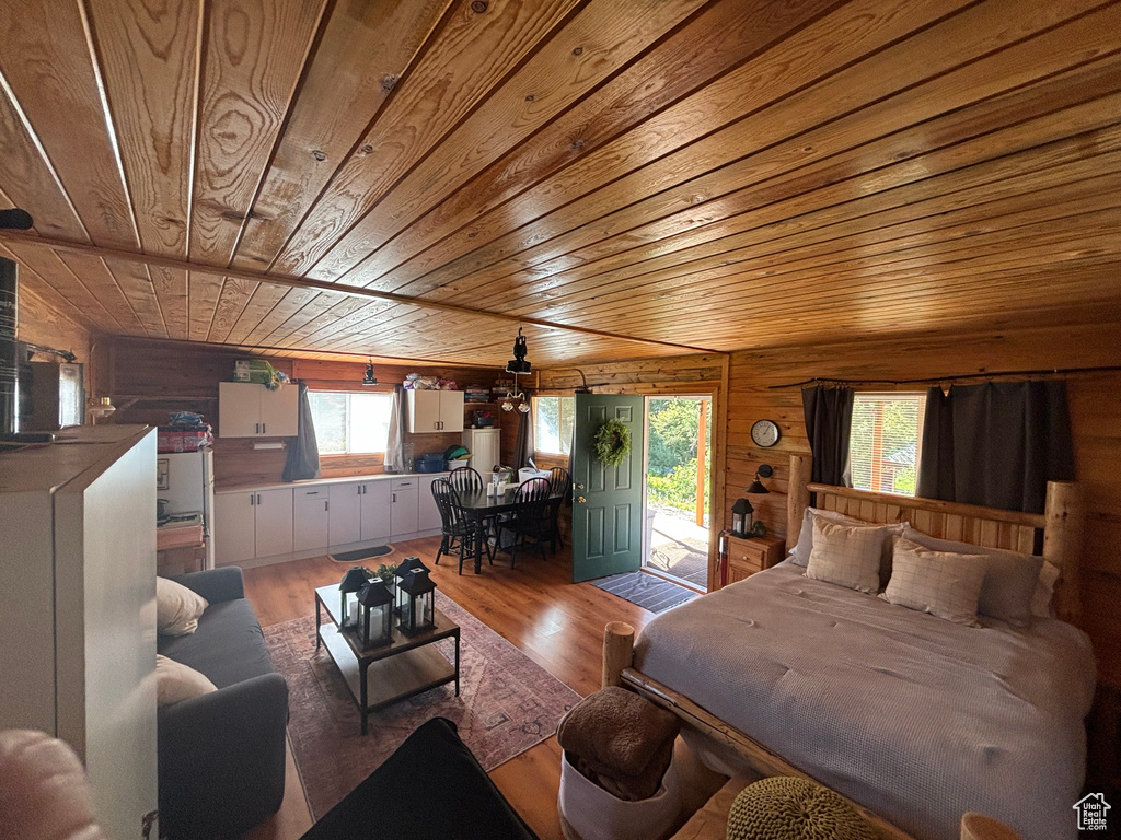 Bedroom with hardwood / wood-style floors, wooden walls, and wood ceiling