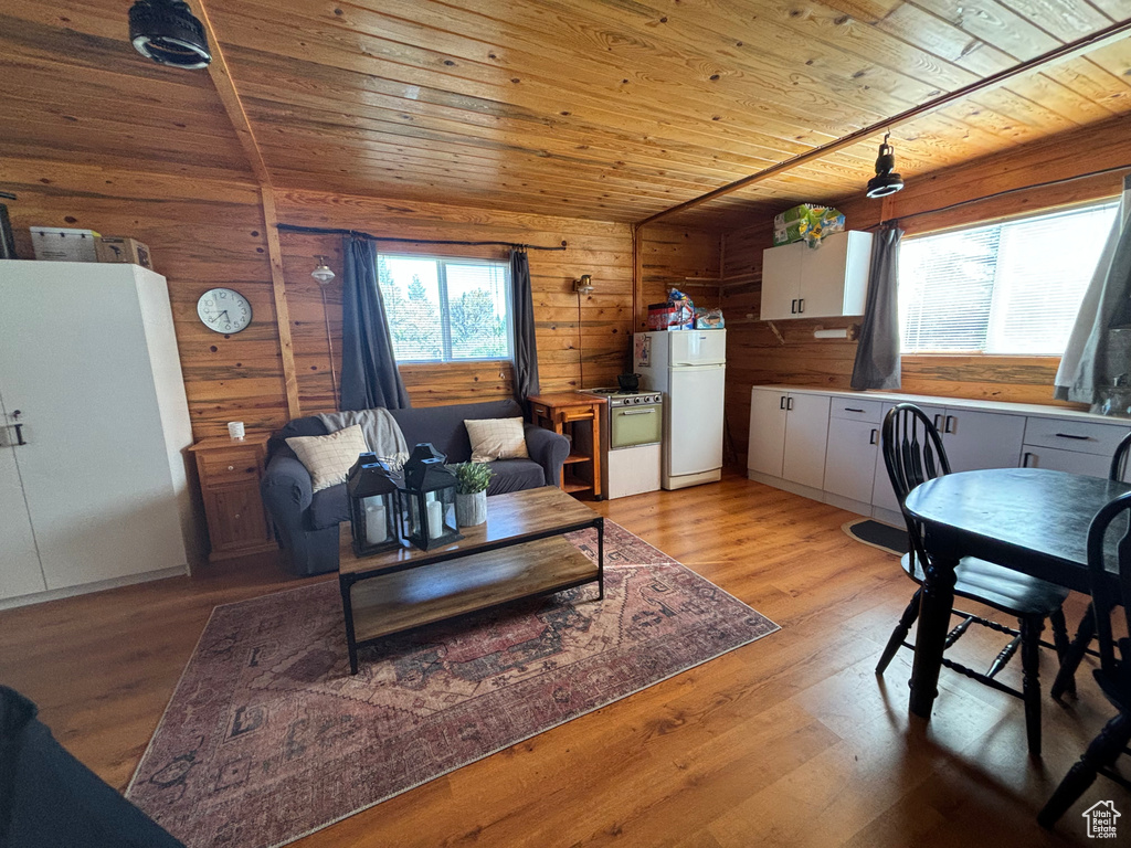 Living room with wood ceiling, wood walls, and light hardwood / wood-style flooring