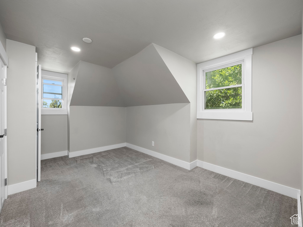 Additional living space with carpet floors and lofted ceiling