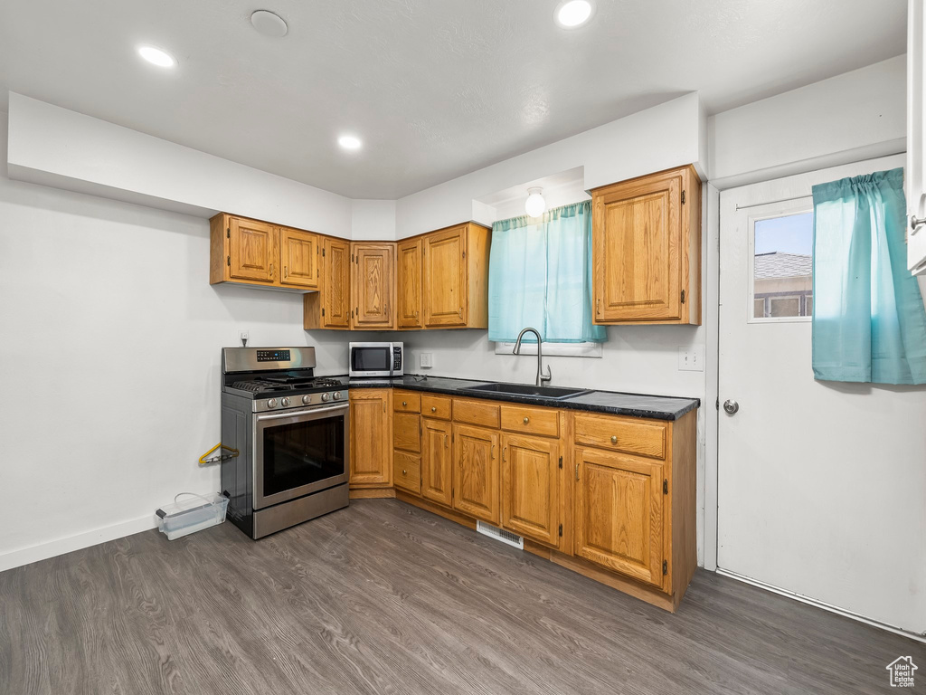 Kitchen featuring appliances with stainless steel finishes, sink, and dark hardwood / wood-style floors