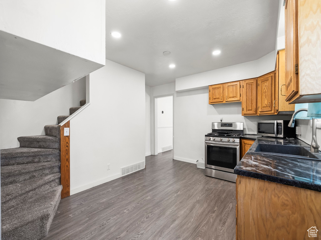 Kitchen featuring dark hardwood / wood-style flooring, sink, and stainless steel appliances