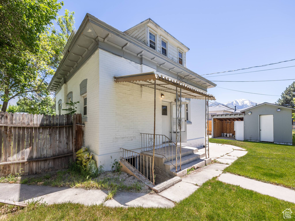 Back of house featuring an outdoor structure and a lawn