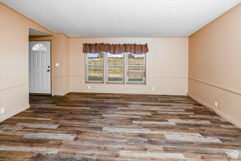 Unfurnished room with dark hardwood / wood-style flooring and crown molding