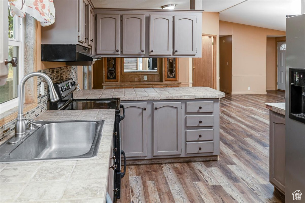 Kitchen featuring sink, gray cabinets, hardwood / wood-style floors, and tile counters