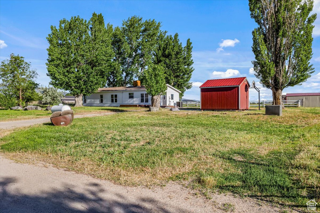 Exterior space featuring a front lawn and a storage unit