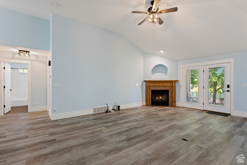 Unfurnished living room with lofted ceiling, ceiling fan, and hardwood / wood-style floors