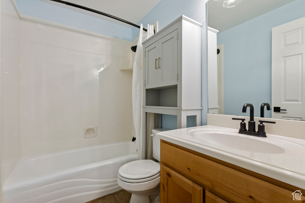 Full bathroom featuring bathing tub / shower combination, vanity, toilet, and tile floors