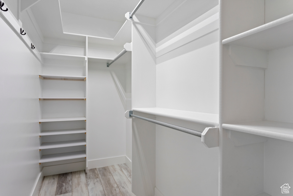 Spacious closet featuring light hardwood / wood-style flooring