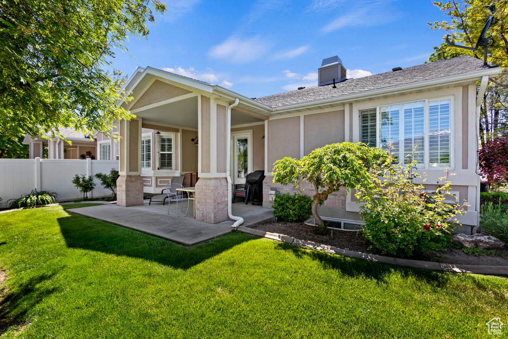 Back of property featuring a patio and a yard