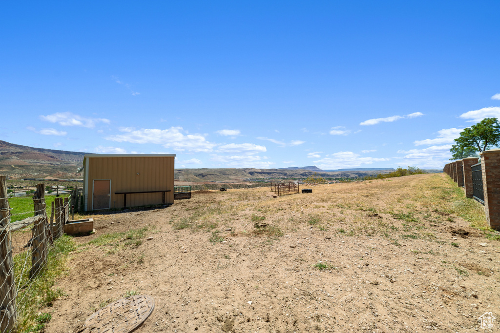 View of yard with a mountain view, a storage unit, and a rural view