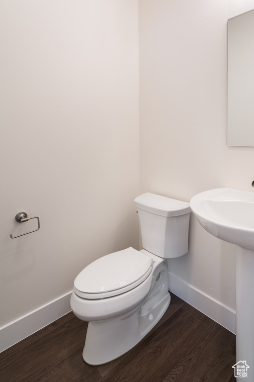 Bathroom featuring toilet, hardwood / wood-style floors, and sink