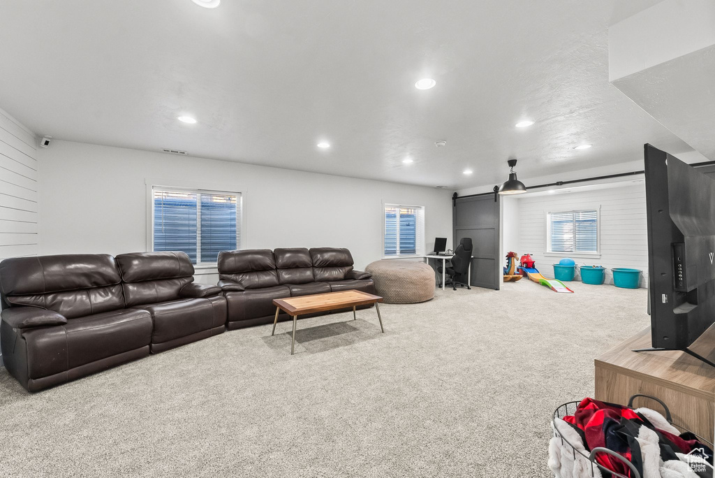 Living room featuring a barn door and carpet flooring