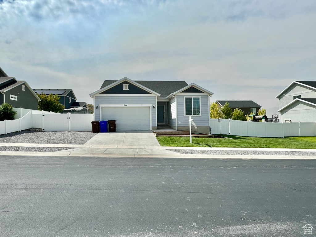 View of front facade featuring a front yard and a garage