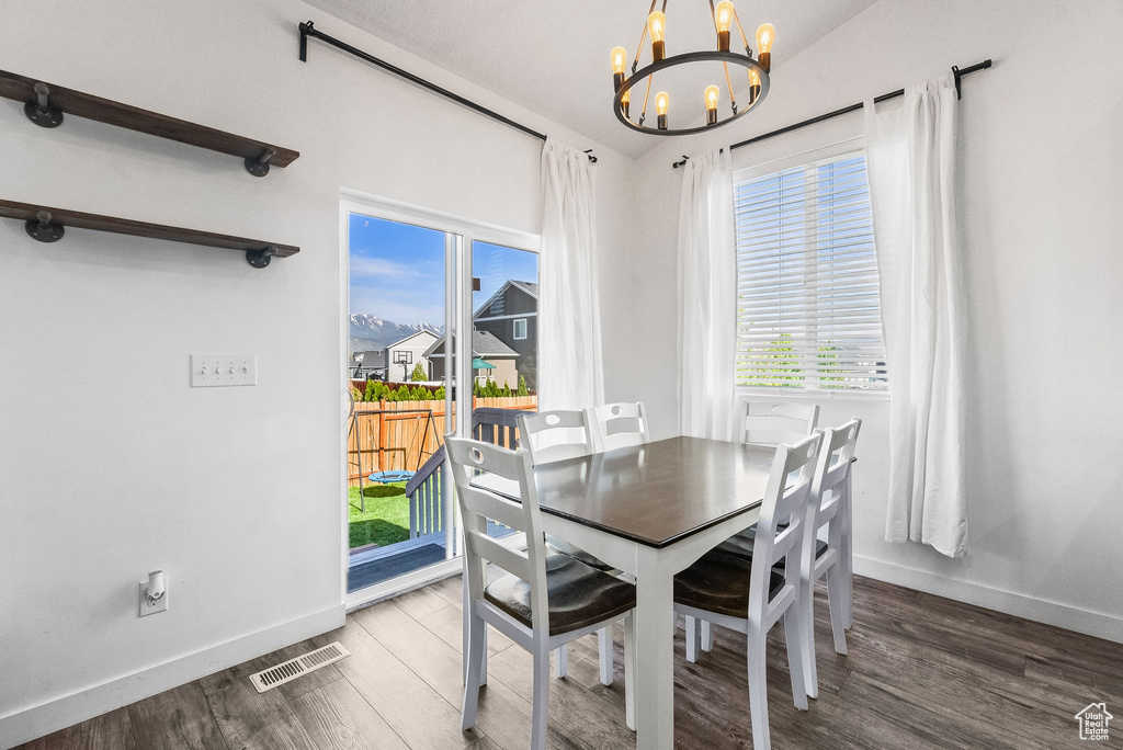 Dining area featuring an inviting chandelier and dark hardwood / wood-style flooring