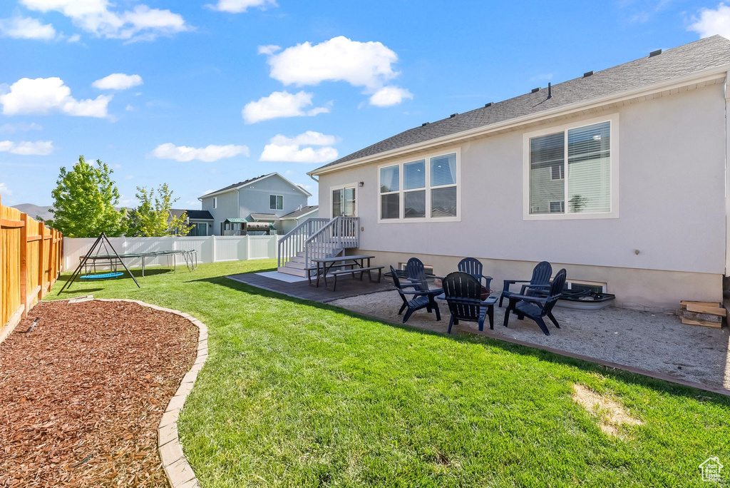 View of yard featuring a patio, a trampoline, and a fire pit