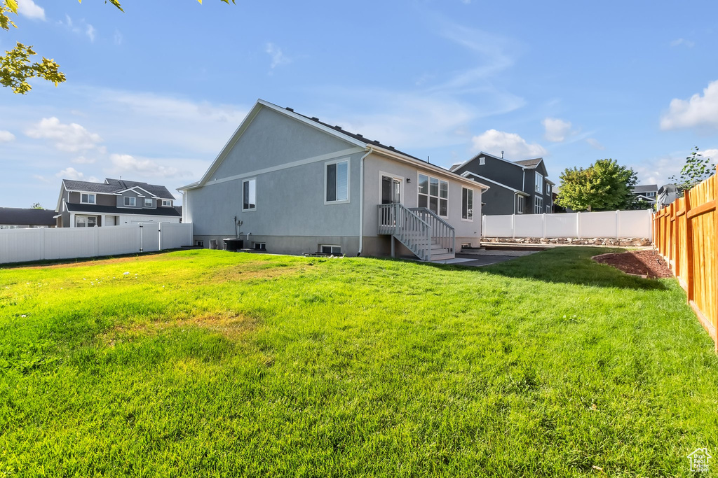 Rear view of house with a yard