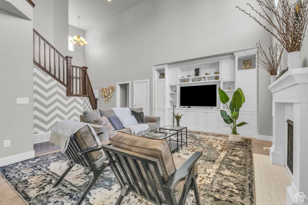 Living room featuring a notable chandelier, a towering ceiling, and built in shelves