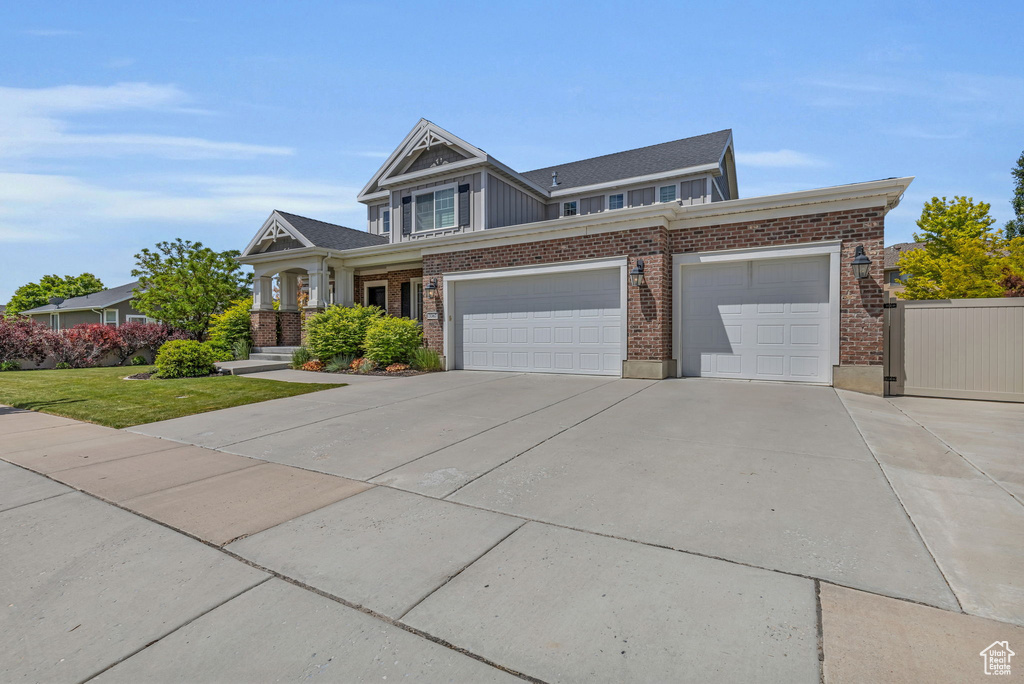 View of front of property featuring a garage and a front yard