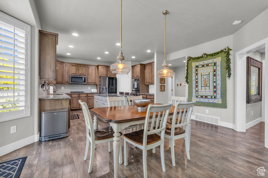 Dining room with dark hardwood / wood-style floors and sink