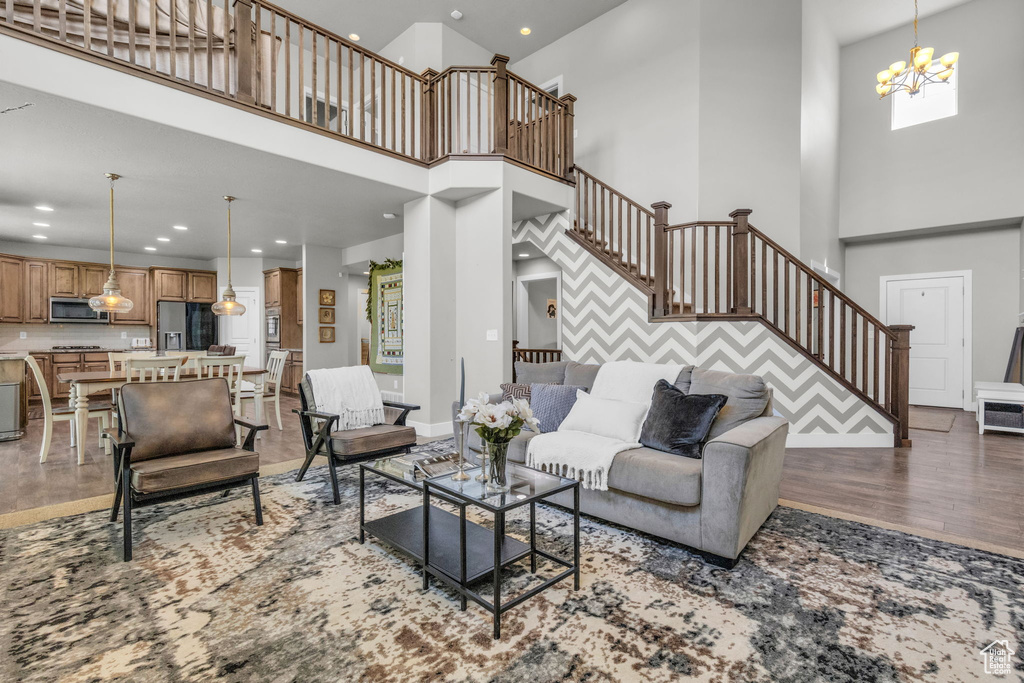 Living room featuring a high ceiling, an inviting chandelier, and hardwood / wood-style floors