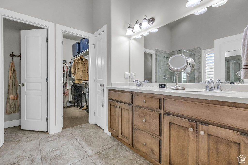 Bathroom featuring tile floors, oversized vanity, and dual sinks