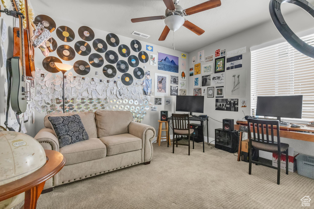 Carpeted living room featuring ceiling fan