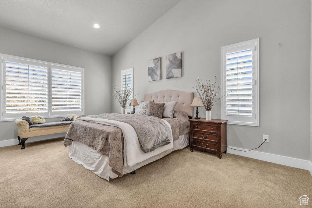 Bedroom with vaulted ceiling and light carpet