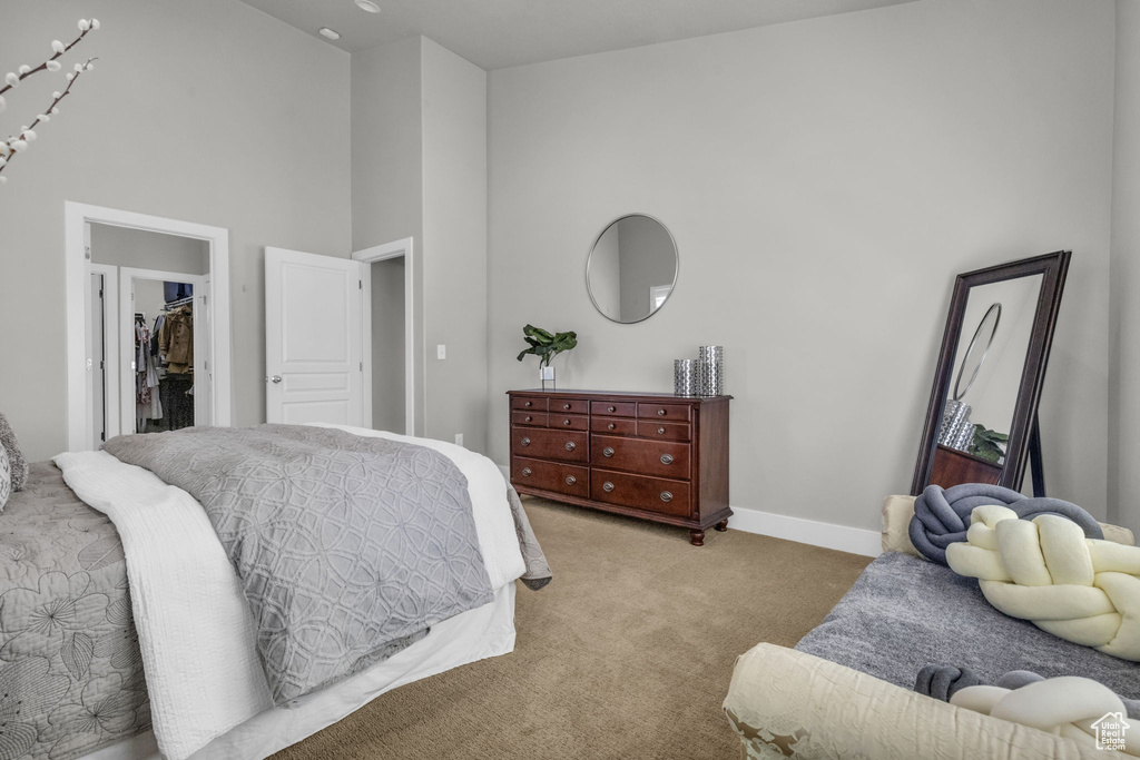 Carpeted bedroom featuring a towering ceiling