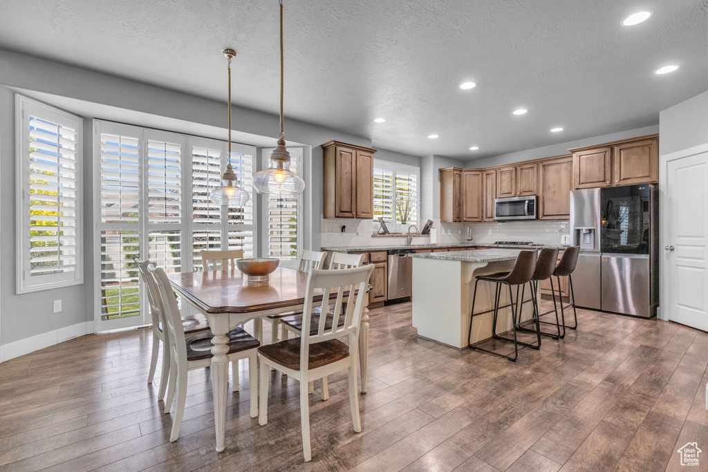 Dining space with a textured ceiling and dark hardwood / wood-style floors