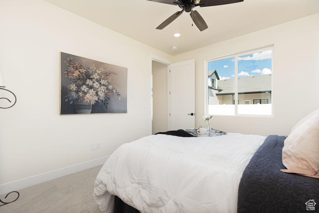 Carpeted bedroom featuring ceiling fan