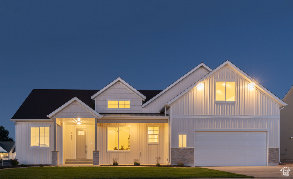 View of front of property with a garage and a yard