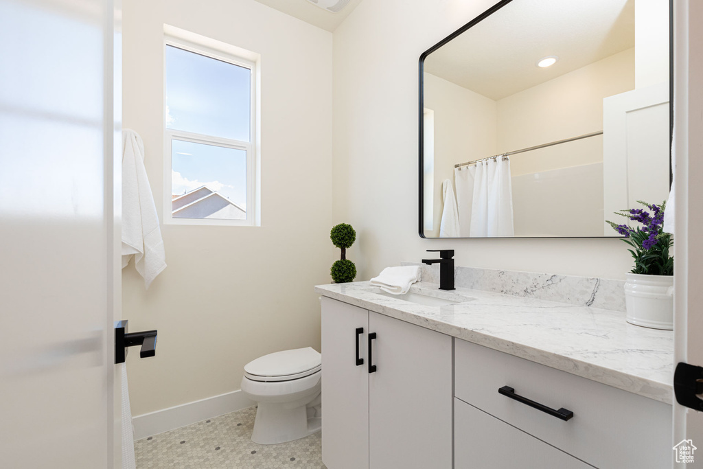 Bathroom with tile patterned flooring, a shower with shower curtain, vanity, and toilet