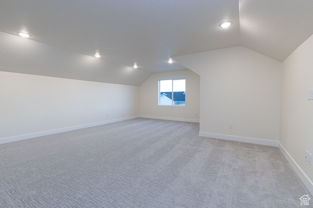 Bonus room featuring light carpet and lofted ceiling