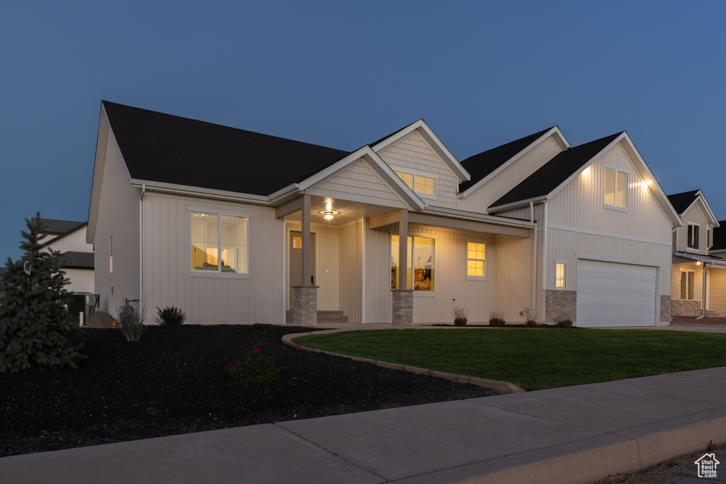 View of front of property featuring a garage and a yard