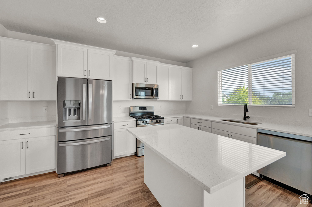 Kitchen featuring appliances with stainless steel finishes, sink, and light wood-type flooring