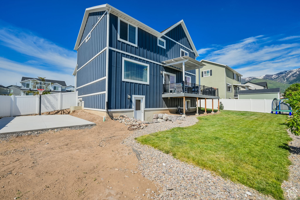 Rear view of house featuring a patio area and a lawn