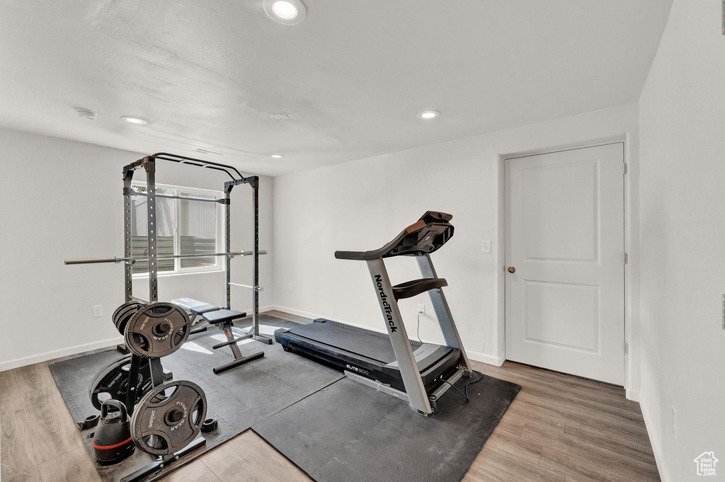 Workout room with wood-type flooring