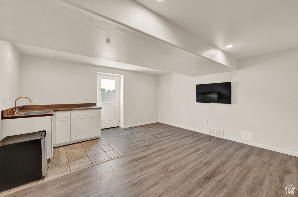 Unfurnished living room featuring sink and light tile floors