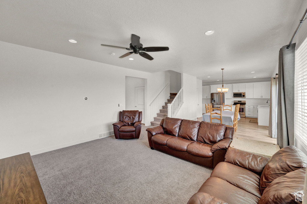 Carpeted living room with ceiling fan