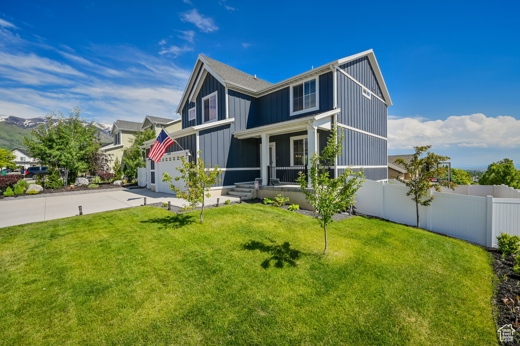 View of front of property featuring a garage, a front yard, and a porch